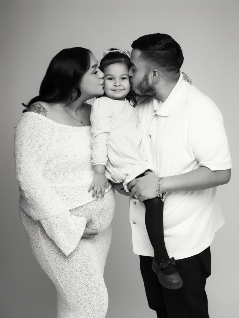 Black and white family portrait with parents holding their toddler during a maternity session in phoenix